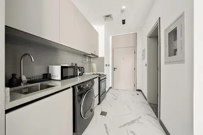 a kitchen with a sink and a microwave at Bright Studio in MAG Eye in Dubai