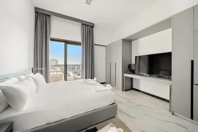 a bedroom with a large bed and a flat screen tv at Bright Studio in MAG Eye in Dubai