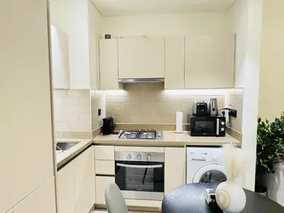 a kitchen with white cabinets and a stove top oven at Creek Views 1 BR, Mins to Downtown in Sobha Creek Vistas in Dubai