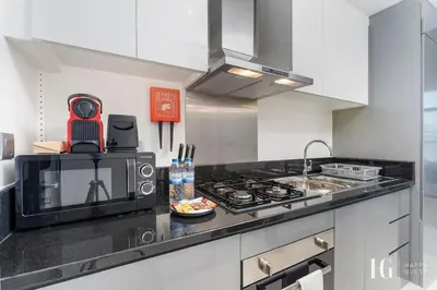 a kitchen with a microwave and a counter top at Spacious Studio in Damac Maison Prive Canal Views in Dubai