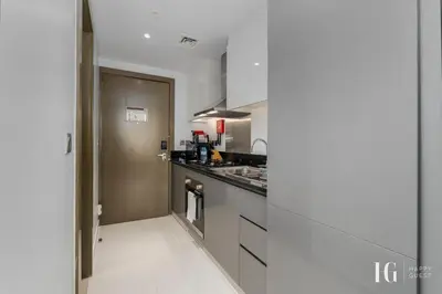 a kitchen with stainless steel appliances and a hallway at Spacious Studio in Damac Maison Prive Canal Views in Dubai