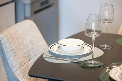 a table with a plate and two wine glasses at Luxury 2BR Burj Khalifa View Dubai Mall in Dubai