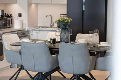 a dining room table with chairs and a vase of flowers at Luxury 2BR Burj Khalifa View Dubai Mall in Dubai
