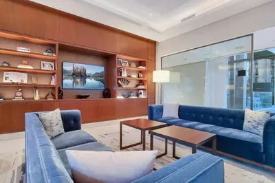 a living room with blue couches and a table at FIRST CLASS 3BR Burj Khalifa & Fountain View in Dubai