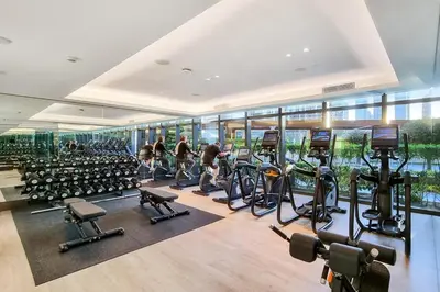 a gym with a lot of treadmills and exercise bikes at FIRST CLASS 3BR Burj Khalifa & Fountain View in Dubai