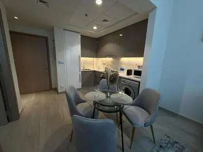 a dining room with a table and chairs in a kitchen at Cozy 01 BHK with Balcony in Dubai
