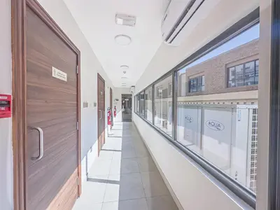 an empty hallway in a hospital with windows at Escape24 Modern 1BR with Pool View in JVC in Dubai