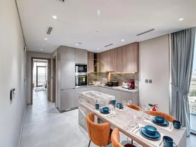 a kitchen with a table and some chairs in it at Luxury 1BR Larger Layout Westwood Grande - 1103 in Dubai