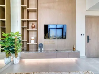 a living room with a tv on a wall at Luxury 1BR Larger Layout Westwood Grande - 1103 in Dubai