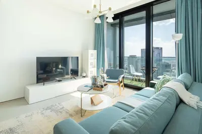 a living room with a blue couch and a tv at Frank Porter - Address JBR in Dubai