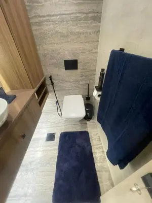 a bathroom with a toilet and a blue shower curtain at Elegant 1BR at Sparkle T1 With Marina View Near Beach in Dubai