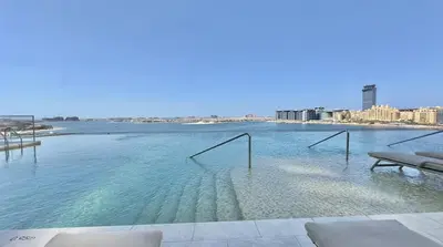 a swimming pool with a view of the water at Grand Bleu 02 - LIMITED OFFER! 1BR Coastal Retreat at Emaar Beachfront in Dubai