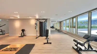 a gym with treadmills and exercise equipment in a building at Grand Bleu 02 - LIMITED OFFER! 1BR Coastal Retreat at Emaar Beachfront in Dubai