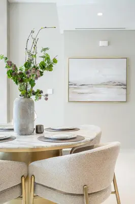 a dining room table with chairs and a vase with flowers at Grand Bleu 02 - LIMITED OFFER! 1BR Coastal Retreat at Emaar Beachfront in Dubai