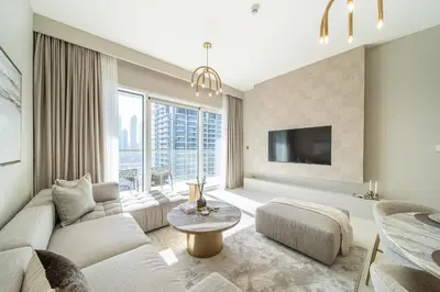 a living room with a couch and a tv at Grand Bleu 02 - LIMITED OFFER! 1BR Coastal Retreat at Emaar Beachfront in Dubai