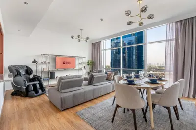 a living room with a couch and a table and chairs at GuestReady - Coastal vibes in Dubai Marina in Dubai