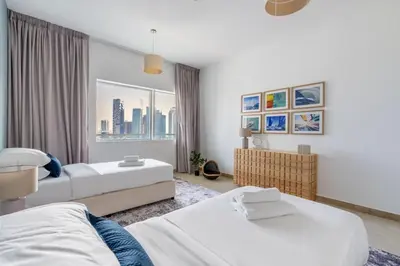 a bedroom with two beds and a window at GuestReady - Coastal vibes in Dubai Marina in Dubai