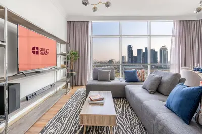 a living room with a flat screen tv and a large window at GuestReady - Coastal vibes in Dubai Marina in Dubai