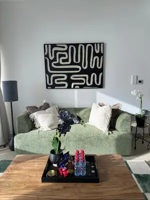 a living room with a green couch and a table at Sea View Luxury 5242 Marina JBR Beach 5mins in Dubai