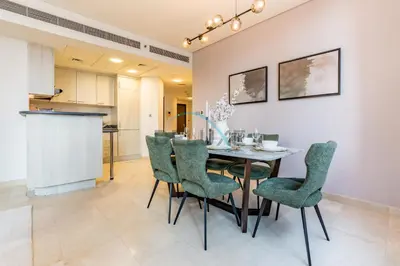 a dining room with a table and green chairs at Modern 2BR in Sky Gardens, DIFC by Deluxe Holiday Homes in Dubai