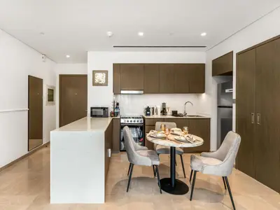 a kitchen with a table and chairs in a kitchen at Signature Series 1 Bedroom Apartment I Free Parking, Gym, Pool I PlayStation 5 I by Skyline Serenity in Dubai