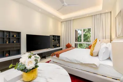 a bedroom with a large bed and a flat screen tv at White Sage Incredible Studio Next to Metro in Dubai