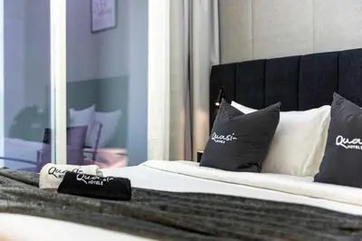 a bed with black and white pillows and a mirror at Luxury 2BD Apt with Pool GYM & Burj Khalifa Views in Dubai
