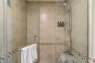 a bathroom with a shower with a glass door at Luxury 2BD Apt with Pool GYM & Burj Khalifa Views in Dubai
