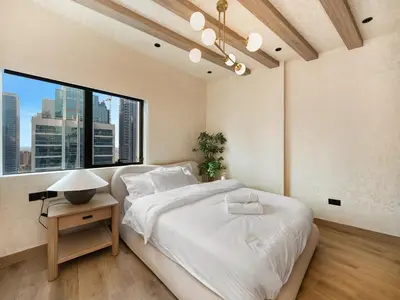 a bedroom with a large bed and a large window at Luxury Penthouse In The Heart of Dubai Marina in Dubai