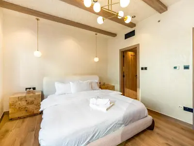 a bedroom with a large white bed with a wooden floor at Luxury Penthouse In The Heart of Dubai Marina in Dubai