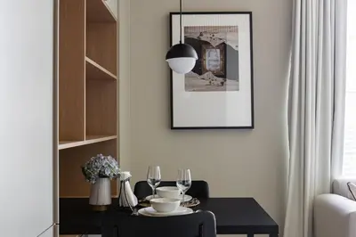 a dining room with a black table and a picture at Upside Living Business Bay Stunning Panoramic Burj Cityline Views by Simply Comfort in Dubai