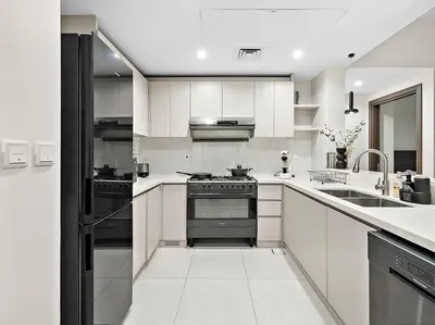 a kitchen with white cabinets and a black oven at FIRST CLASS 2BR Panoramic Views of Dubai Frame in Dubai