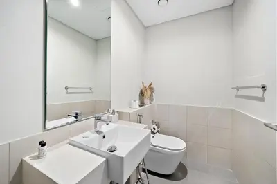 a white bathroom with a sink and a toilet at FIRST CLASS 2BR Panoramic Views of Dubai Frame in Dubai