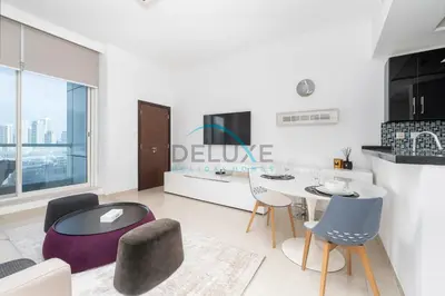 a living room with a dining table and chairs at Spectacular 1BR in Botanica Tower 1 Dubai Marina by Deluxe Holidy Homes in Dubai