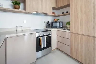 a white kitchen with a stove and a microwave at Frank Porter - Urban Oasis in Dubai