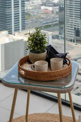 a table with two cups and a potted plant on it at Frank Porter - Urban Oasis in Dubai