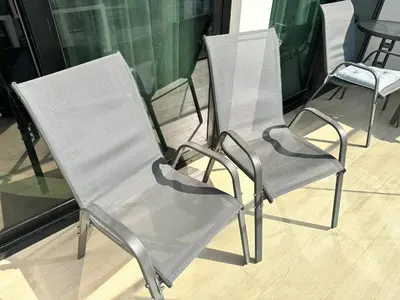 a couple of chairs sitting next to a table at Chic Jvc 1br Balcony, Pool And Parking in Dubai
