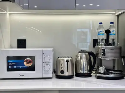 a kitchen counter with a microwave and a coffee maker at Chic Jvc 1br Balcony, Pool And Parking in Dubai