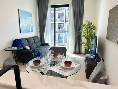 a living room with a couch and a table at Chic Jvc 1br Balcony, Pool And Parking in Dubai