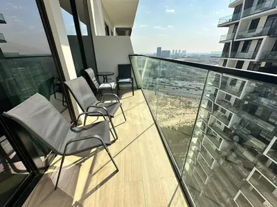 a balcony with chairs and a view of a city at Chic Jvc 1br Balcony, Pool And Parking in Dubai