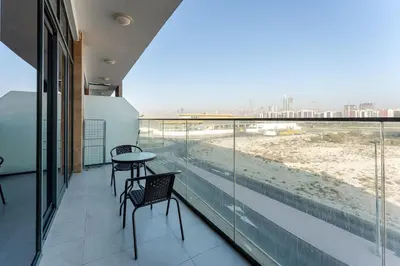 a balcony with a table and chairs and a view of the beach at HAVN - 1 Bedroom in Azizi Park Avenue, Meydan in Dubai