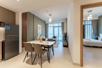 a kitchen and living room with a table and chairs at HAVN - 1 Bedroom in Azizi Park Avenue, Meydan in Dubai
