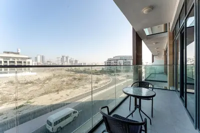 a balcony with a table and chairs and a view of a street at HAVN - 1 Bedroom in Azizi Park Avenue, Meydan in Dubai