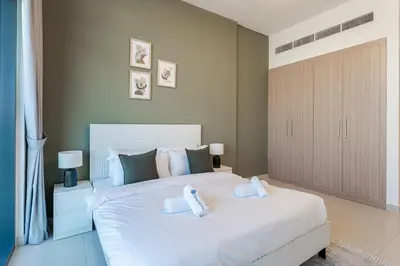 a bedroom with a large white bed with two pillows at HAVN - 1 Bedroom in Azizi Park Avenue, Meydan in Dubai