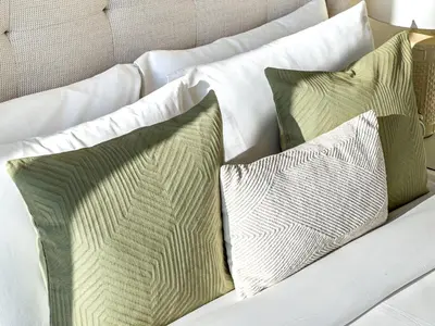 a white couch with four pillows on it at Premium 3BR l Office with Burj Khalifa & Fountain Views in Dubai