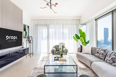 a living room with a couch and a tv at Premium 3BR l Office with Burj Khalifa & Fountain Views in Dubai