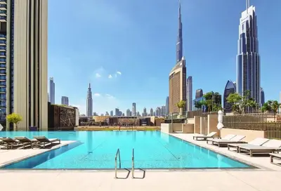 a swimming pool with a view of the city at Premium 3BR l Office with Burj Khalifa & Fountain Views in Dubai