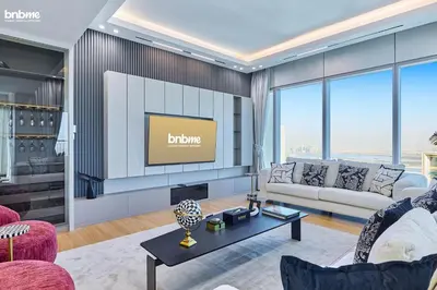 a living room with a couch and a tv at bnbme - Luxury 4BR Downtown Views II Apt Burj Khalifa Views Pool Gym Parking in Dubai