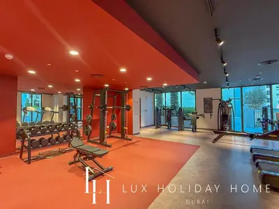 a gym with treadmills and weights in a room at LUX The La Mer Infinity View- Luxury Boho Suite 2 in Dubai