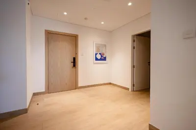 an empty room with a door and wooden floors at HiGuests - Experience Coastal Elegance at La Rive 2 in La Mer in Dubai